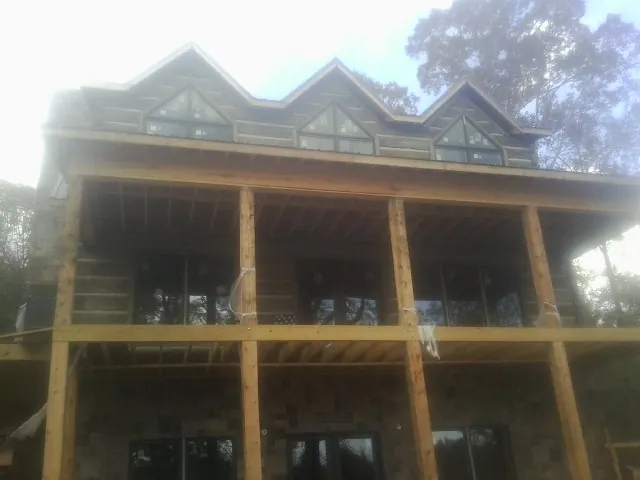Dormers and porch framing on a large log home under construction — Roof Coating work by our crew in Rock Hill