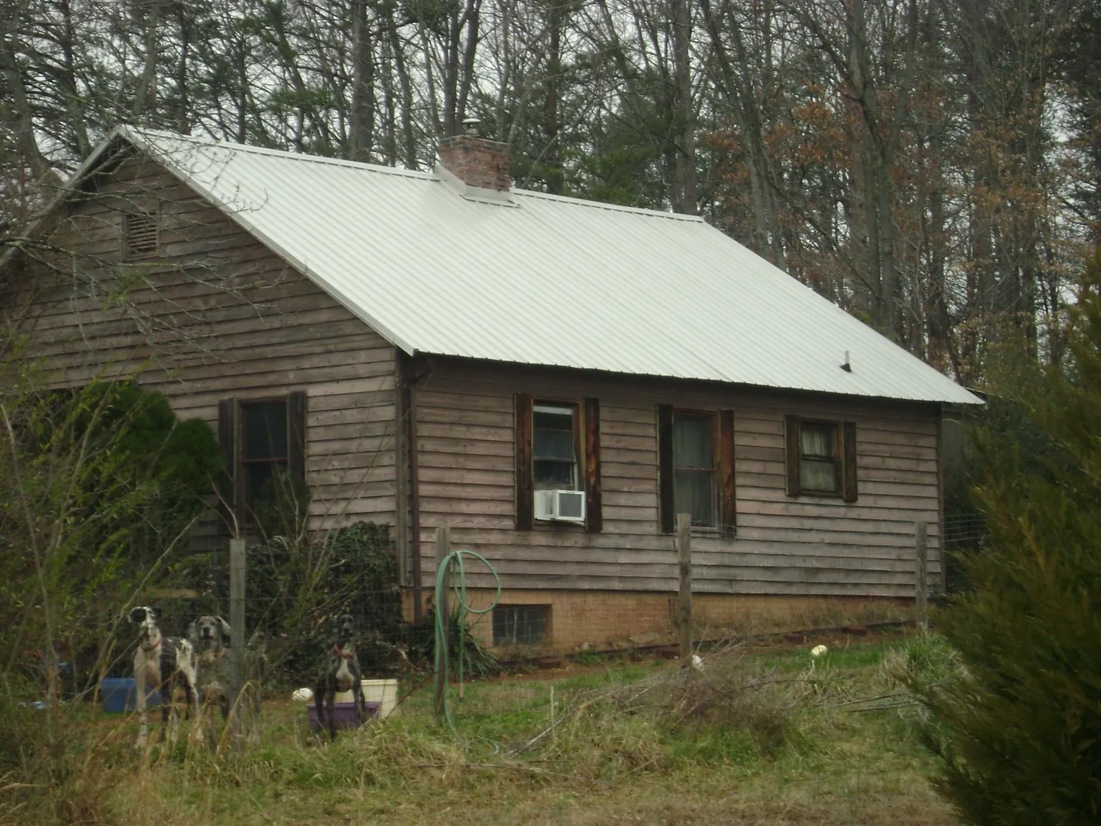 White metal roof on an old wood sided farmhouse, from a Asphalt Shingle Roof Repair job in Rock Hill